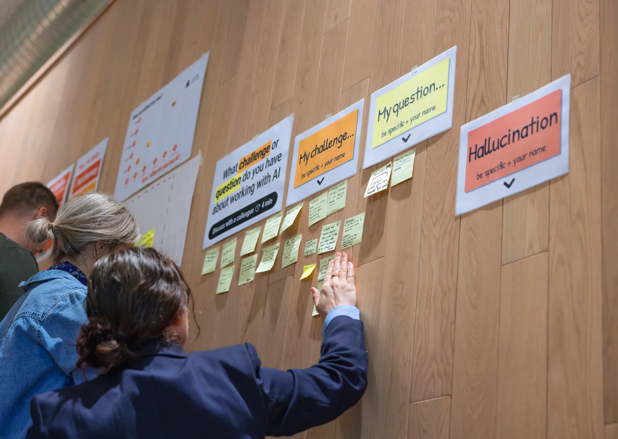 A team reviews a wall of post-its together during a work session at Stokke