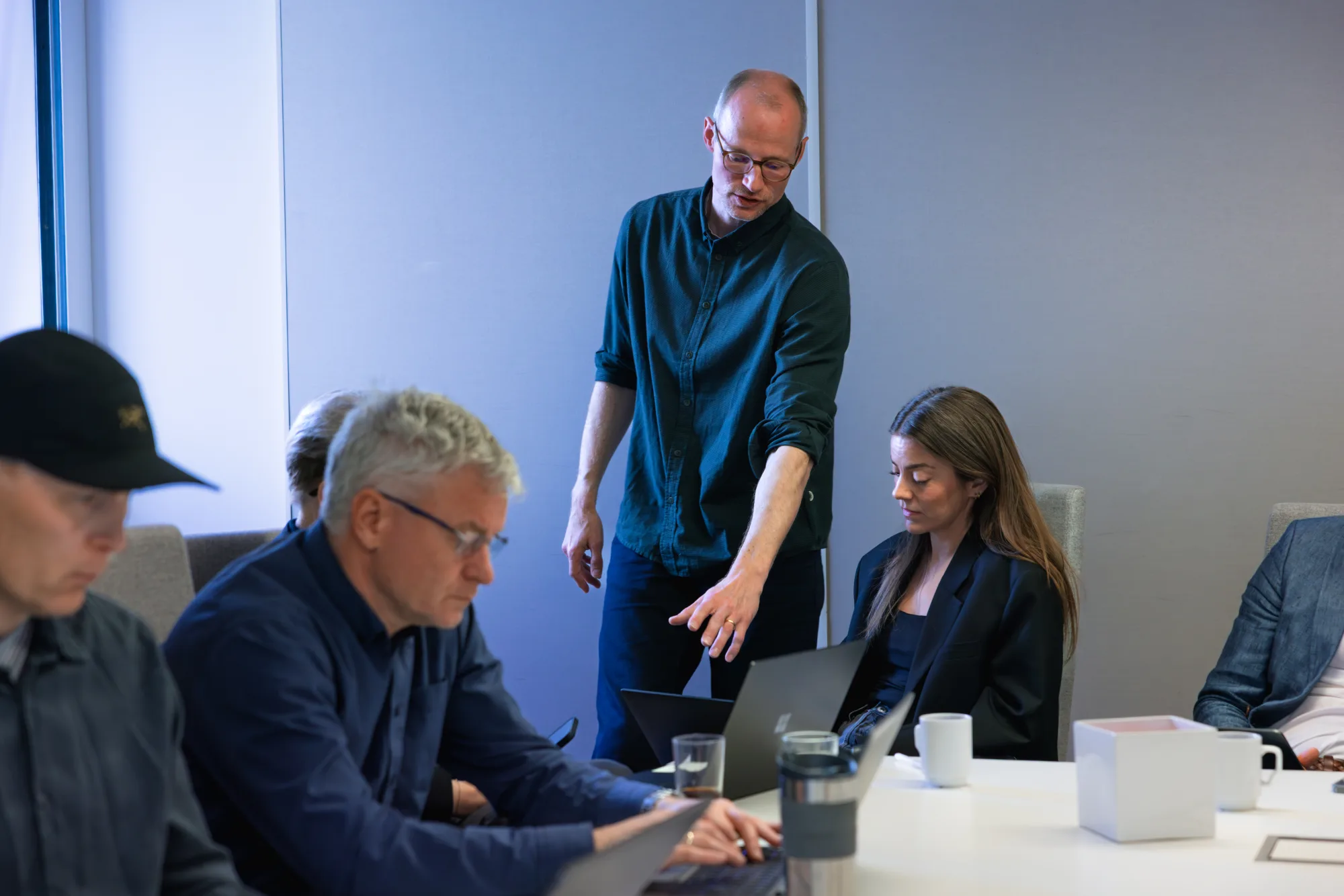 A trainer coaches a participant at the laptop during a work session at Stokke